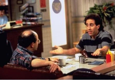 Jerry and George sitting in a booth talking at Monk's Restaurant